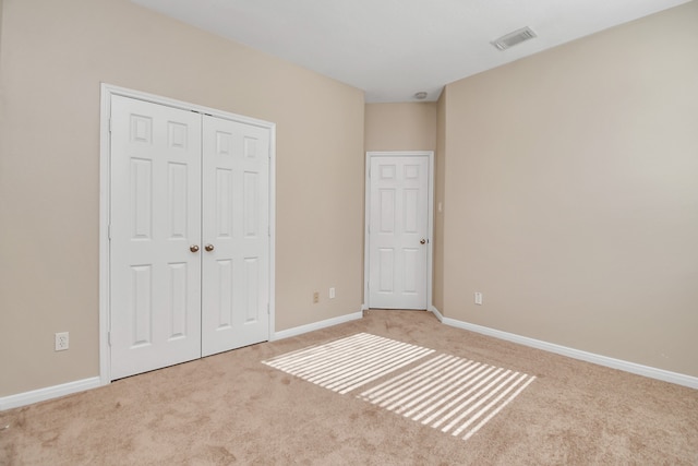 unfurnished bedroom featuring a closet and light carpet