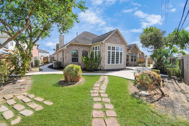 back of house featuring a yard and central AC