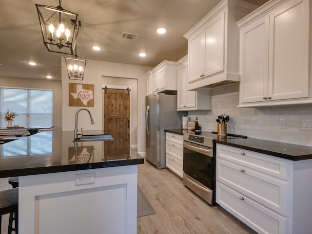 kitchen with sink, light hardwood / wood-style floors, stainless steel appliances, decorative light fixtures, and white cabinets