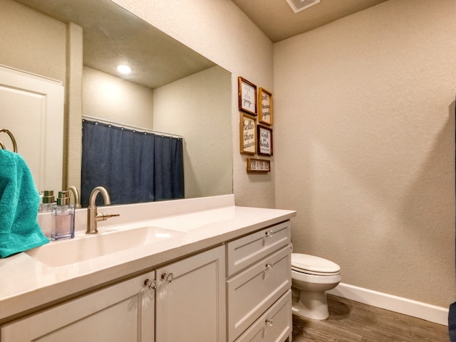 bathroom featuring vanity, toilet, and hardwood / wood-style flooring