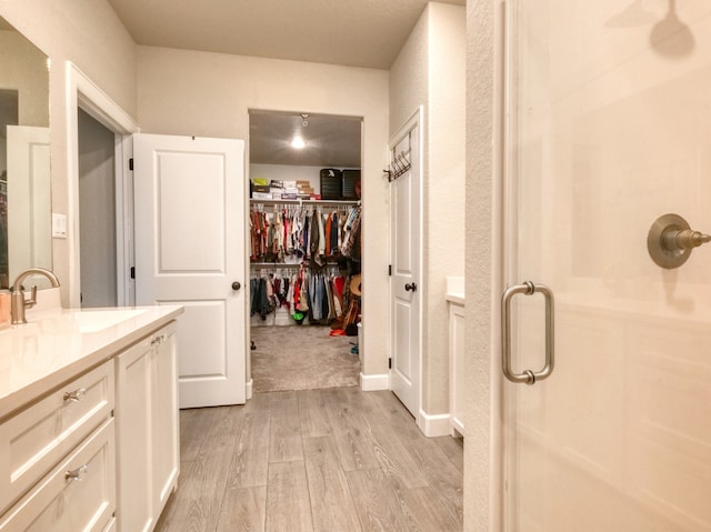 bathroom featuring vanity, hardwood / wood-style floors, and a shower with shower door