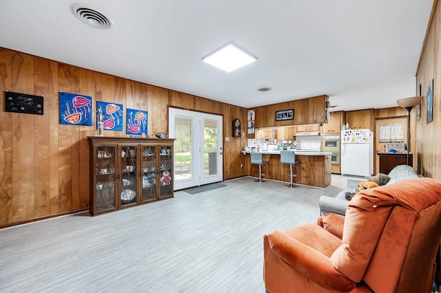 living room featuring light hardwood / wood-style flooring and wooden walls