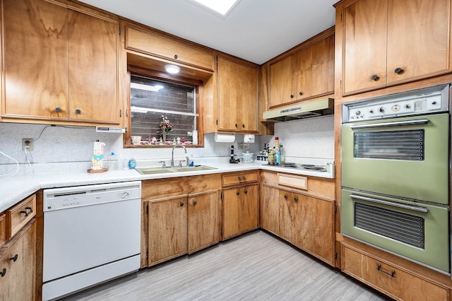 kitchen featuring tasteful backsplash, sink, white appliances, and light hardwood / wood-style floors