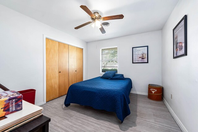 bedroom with ceiling fan, a closet, and light wood-type flooring