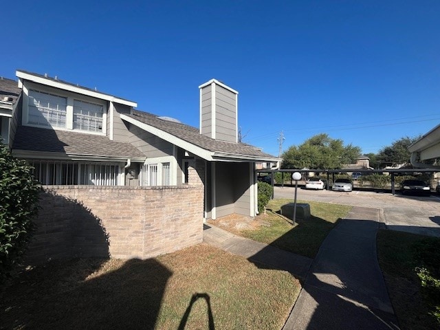 view of side of home with a carport and a lawn