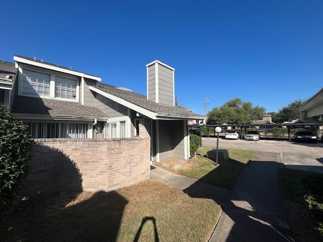 view of side of property featuring a yard and a carport