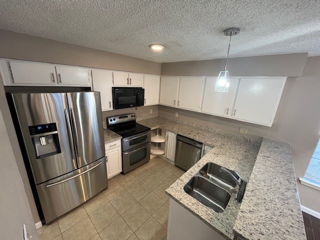 kitchen with sink, white cabinets, pendant lighting, appliances with stainless steel finishes, and light stone counters