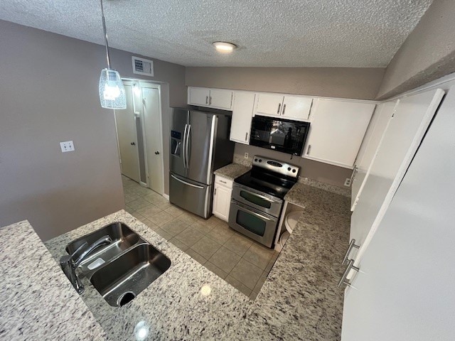 kitchen featuring appliances with stainless steel finishes, sink, lofted ceiling, pendant lighting, and white cabinets