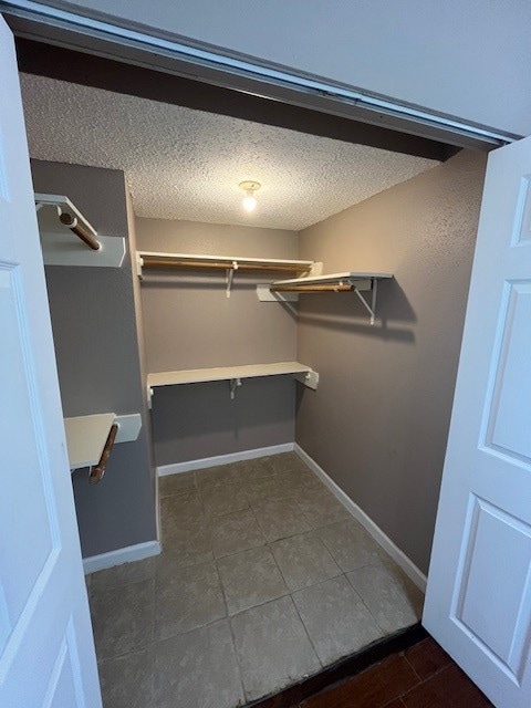 spacious closet featuring dark tile patterned floors