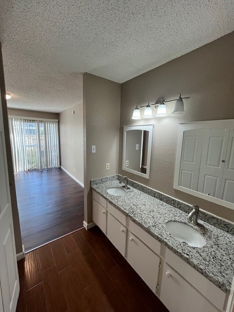 bathroom featuring vanity, hardwood / wood-style floors, and a textured ceiling