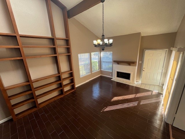 unfurnished living room with a notable chandelier, a textured ceiling, vaulted ceiling, and dark hardwood / wood-style floors