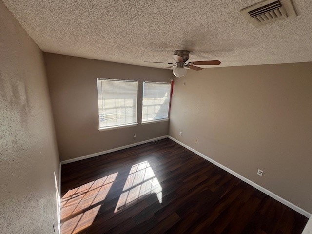 spare room featuring a textured ceiling, ceiling fan, and dark hardwood / wood-style flooring