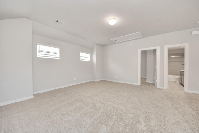 carpeted empty room featuring lofted ceiling