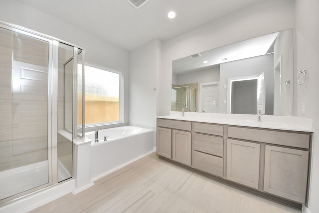 bathroom featuring shower with separate bathtub and vanity