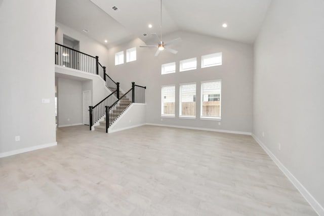 unfurnished living room featuring high vaulted ceiling, light hardwood / wood-style flooring, and ceiling fan