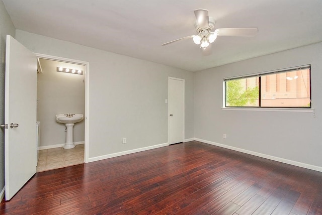 unfurnished bedroom featuring dark wood-type flooring, ceiling fan, and connected bathroom