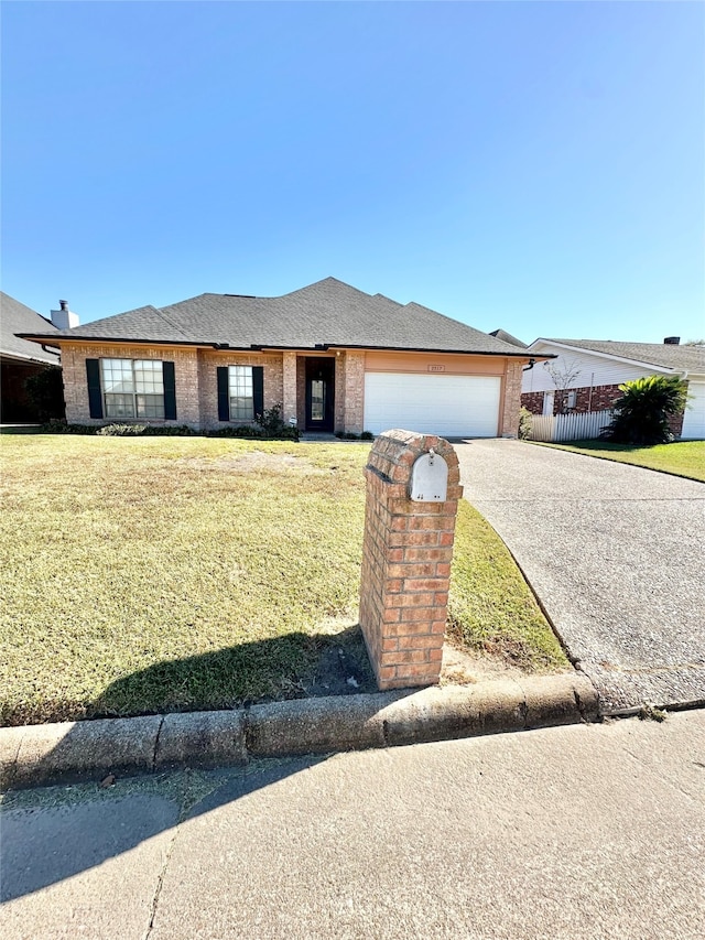 ranch-style home with a garage and a front lawn