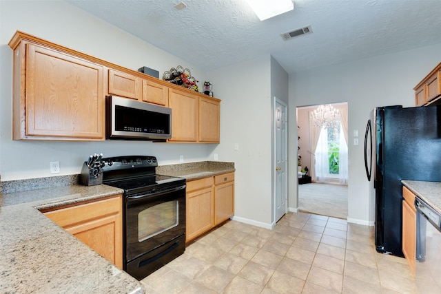 kitchen with black appliances, light brown cabinetry, visible vents, and baseboards