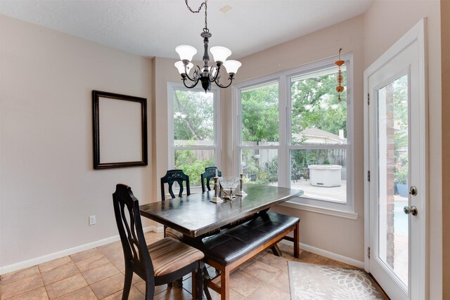 dining area with light tile patterned floors, a notable chandelier, and baseboards