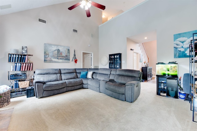 carpeted living room with visible vents, a ceiling fan, and high vaulted ceiling