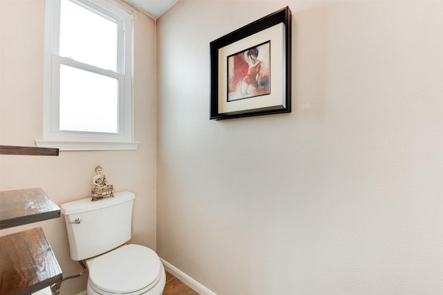 half bath with toilet and baseboards