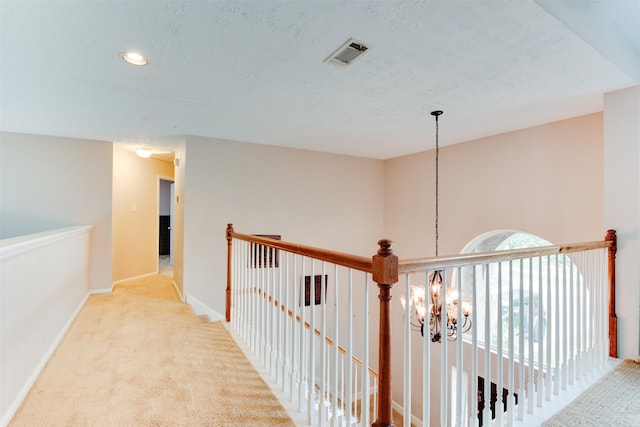 hallway featuring recessed lighting, an inviting chandelier, carpet floors, baseboards, and visible vents