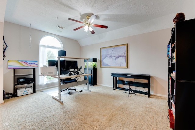 office featuring a ceiling fan, visible vents, vaulted ceiling, baseboards, and carpet floors