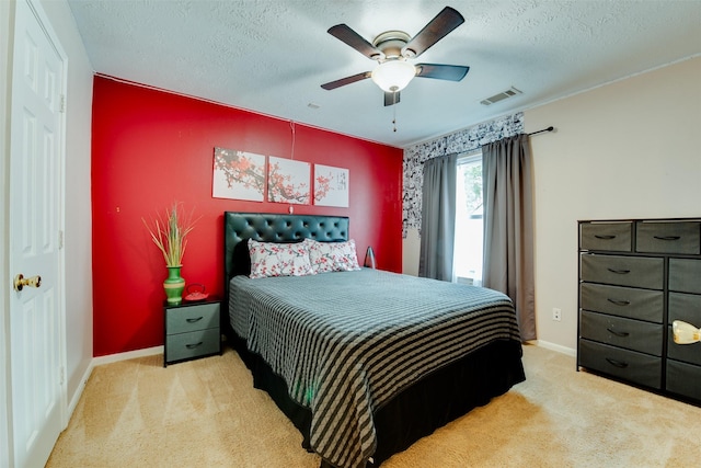 bedroom with an accent wall, carpet, and visible vents