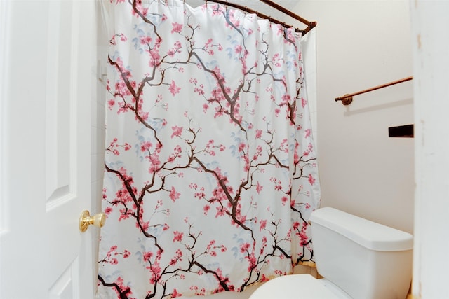 bathroom featuring curtained shower and toilet