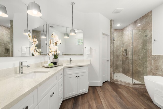 bathroom with shower with separate bathtub, hardwood / wood-style flooring, and vanity