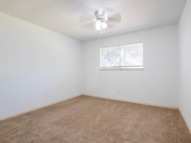 spare room with a textured ceiling, carpet flooring, and ceiling fan