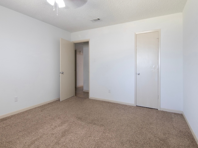 spare room featuring a textured ceiling, ceiling fan, and carpet floors