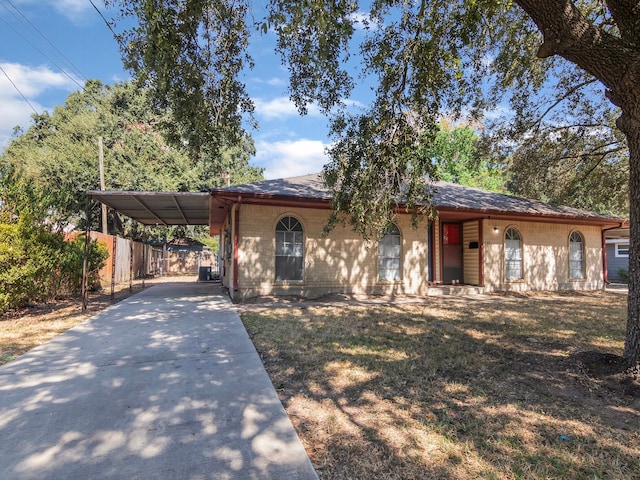 view of front of property featuring a front yard and a carport