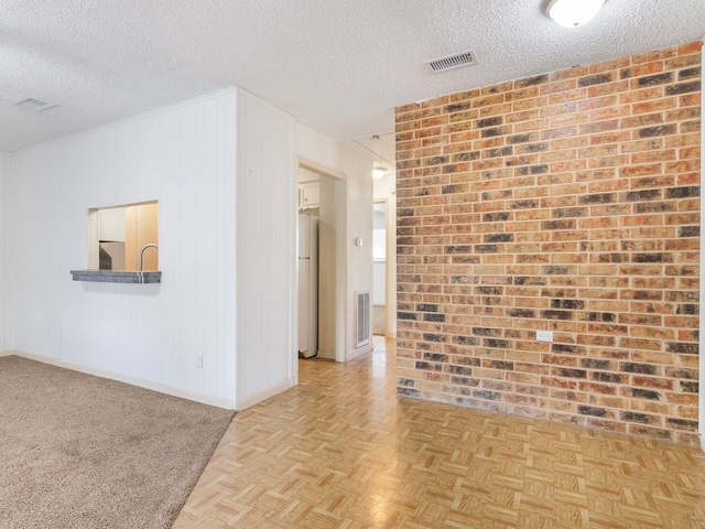 unfurnished room featuring a textured ceiling and light parquet flooring