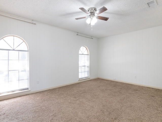 spare room featuring ceiling fan, a healthy amount of sunlight, and carpet floors