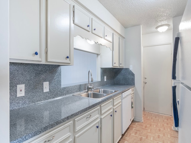 kitchen with light parquet flooring, sink, dishwasher, refrigerator, and white cabinetry