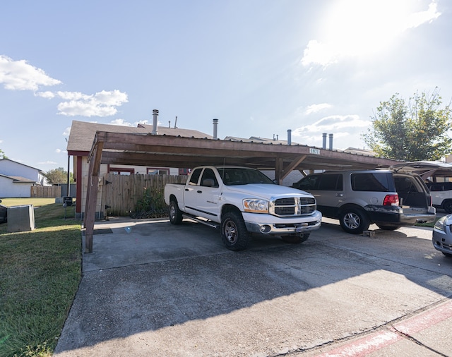 view of vehicle parking with a yard and a carport