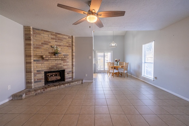 unfurnished living room with ceiling fan, a textured ceiling, a wealth of natural light, and light tile patterned floors