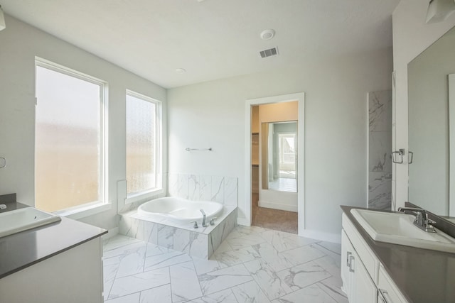 bathroom featuring vanity and a relaxing tiled tub