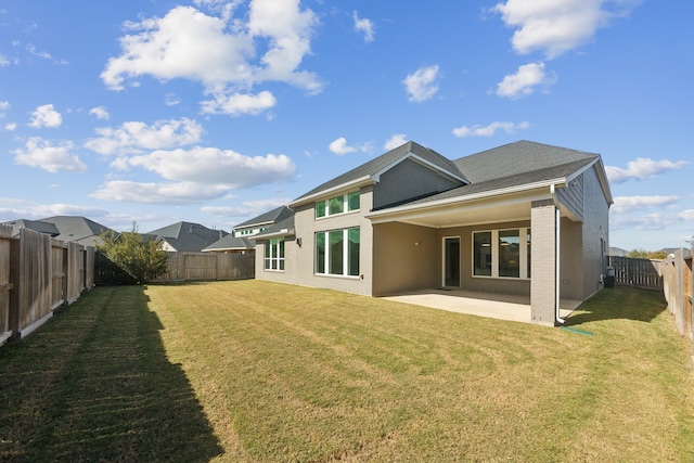 rear view of property with a patio and a lawn