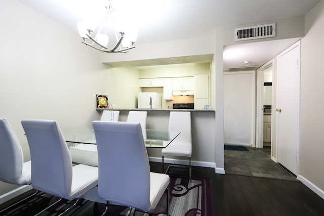 dining space featuring a notable chandelier and dark hardwood / wood-style floors