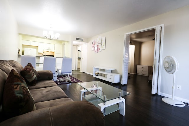 living room featuring an inviting chandelier and dark hardwood / wood-style flooring