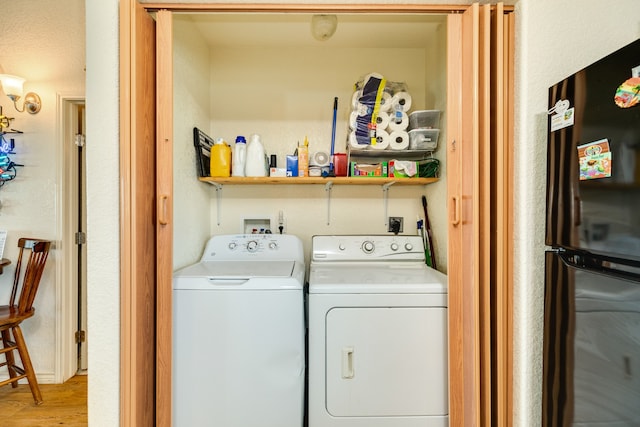 washroom with washer and clothes dryer and light hardwood / wood-style floors