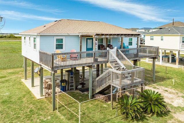 back of property featuring a patio area, a wooden deck, and a lawn