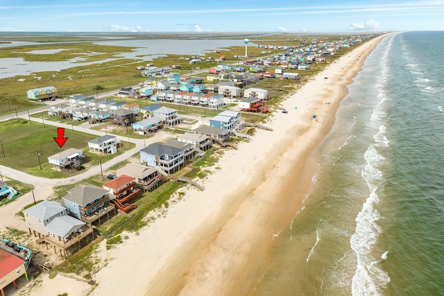 drone / aerial view with a water view and a beach view