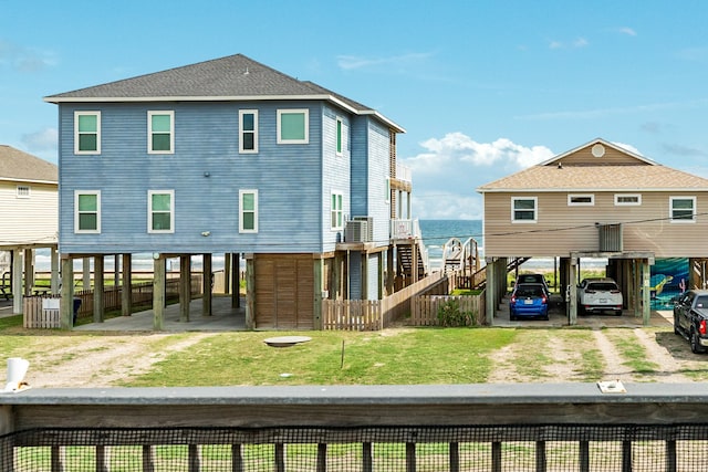 rear view of property with a water view and a lawn