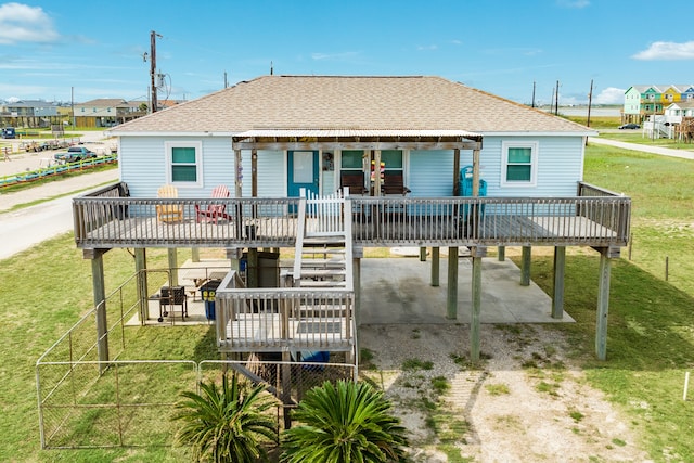 back of property with a wooden deck and a lawn