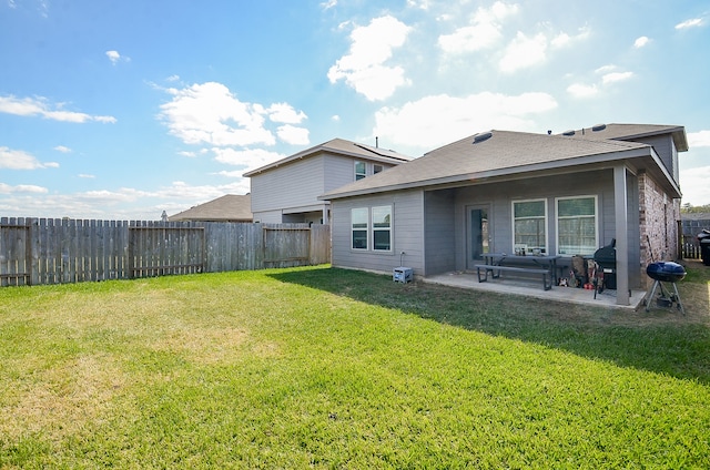 rear view of property with a yard and a patio area