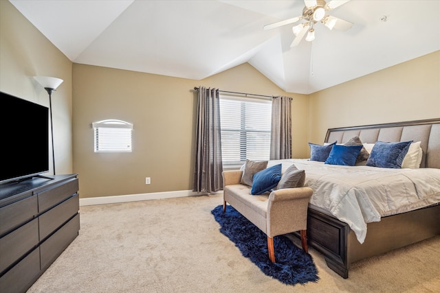 carpeted bedroom with multiple windows, ceiling fan, and vaulted ceiling