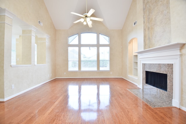 unfurnished living room featuring light hardwood / wood-style floors, high vaulted ceiling, built in features, and ceiling fan